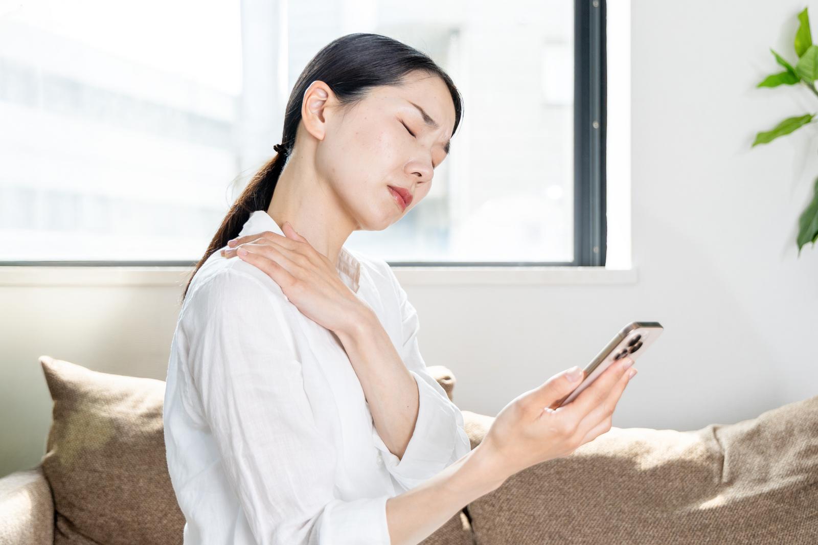 長時間スマホを見て肩が痛い女性
